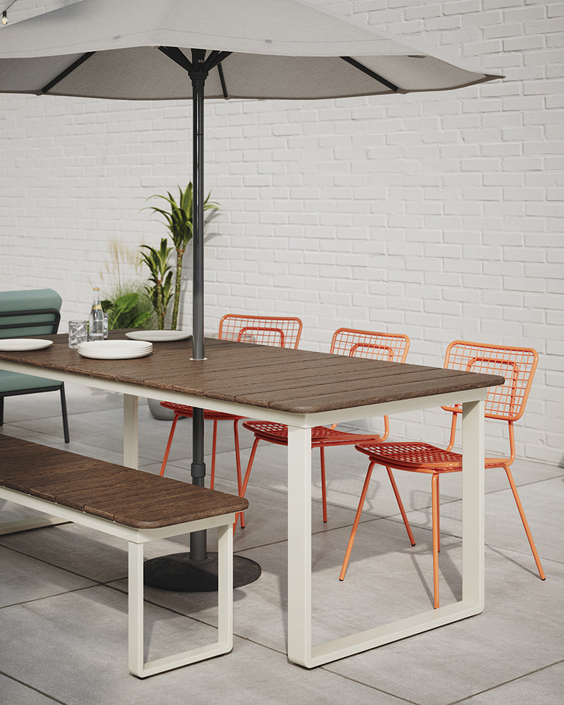 Styled outdoor shot of Bowen Communal Table in Walnut with Gloss White base. Umbrella table. Outdoor bench seating. Kansas City outdoor office furniture.